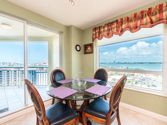 1170 Gulf Blvd Unit 1006, Clearwater Beach, FL 33767 - dining area featuring a view of city, light tile patterned floors, baseboards, and a water view