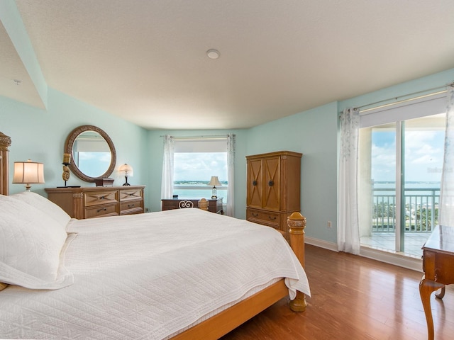 1170 Gulf Blvd Unit 1006, Clearwater Beach, FL 33767 - bedroom featuring access to exterior, wood finished floors, and baseboards