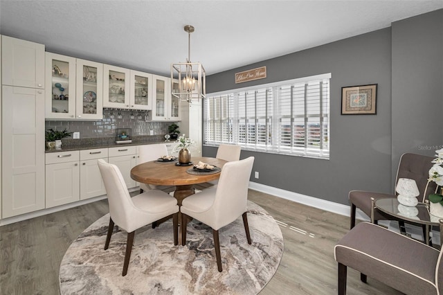 1621 Gulf Blvd Unit 407, Clearwater Beach, FL 33767 - dining area with a chandelier, baseboards, and light wood-style flooring