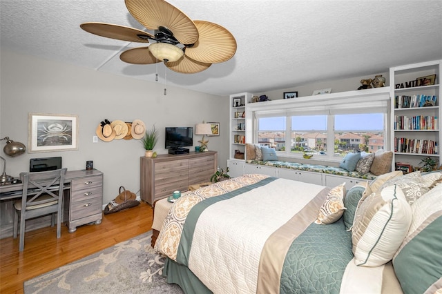 1621 Gulf Blvd Unit 407, Clearwater Beach, FL 33767 - bedroom with light wood-type flooring, a textured ceiling, and a ceiling fan