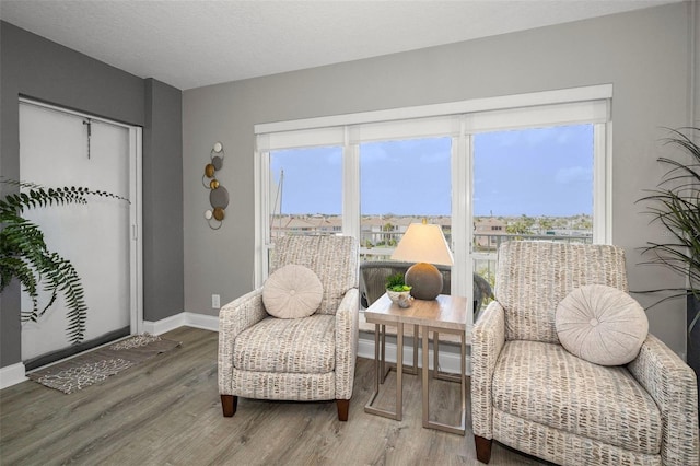 1621 Gulf Blvd Unit 407, Clearwater Beach, FL 33767 - sitting room featuring healthy amount of natural light, wood finished floors, and baseboards