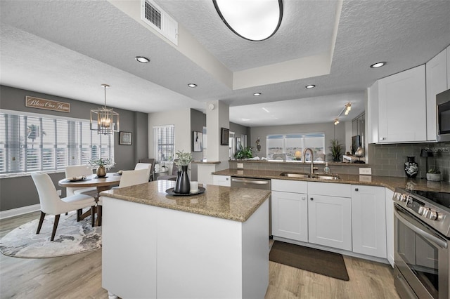 1621 Gulf Blvd Unit 407, Clearwater Beach, FL 33767 - kitchen with a sink, stainless steel appliances, light wood-style flooring, a textured ceiling, and plenty of natural light