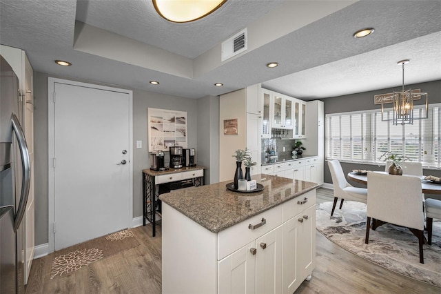 1621 Gulf Blvd Unit 407, Clearwater Beach, FL 33767 - kitchen with freestanding refrigerator, light wood finished floors, a textured ceiling, baseboards, and a chandelier