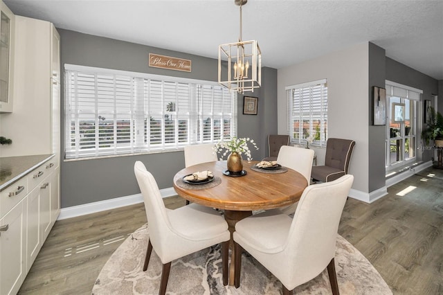 1621 Gulf Blvd Unit 407, Clearwater Beach, FL 33767 - dining room with baseboards, wood finished floors, and a chandelier
