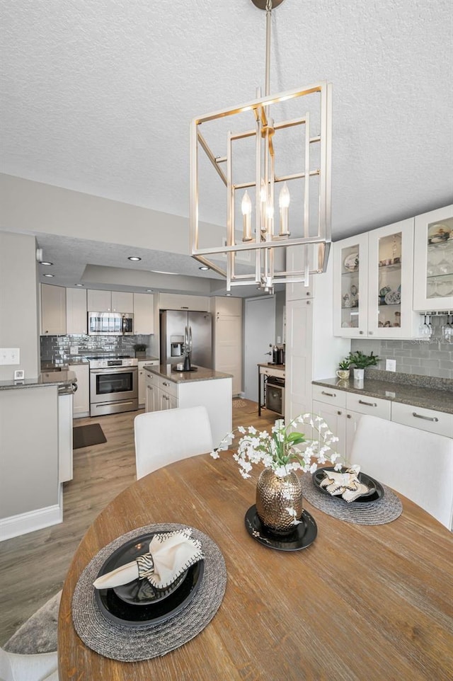 1621 Gulf Blvd Unit 407, Clearwater Beach, FL 33767 - dining room with a chandelier, a textured ceiling, and light wood-type flooring