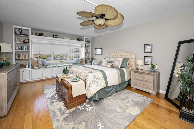 1621 Gulf Blvd Unit 407, Clearwater Beach, FL 33767 - bedroom with light wood-style floors, a textured ceiling, and a ceiling fan
