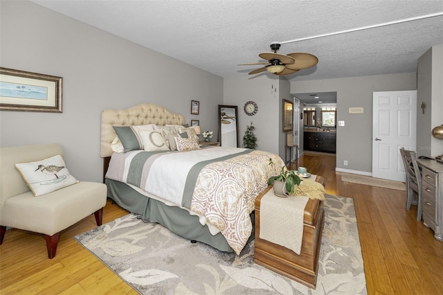 1621 Gulf Blvd Unit 407, Clearwater Beach, FL 33767 - bedroom featuring wood finished floors, ensuite bath, a textured ceiling, and ceiling fan
