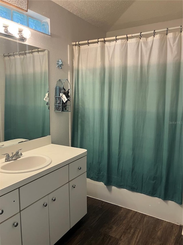 6905 Summer Harbor Ln, Riverview, FL 33578 - bathroom featuring a textured ceiling, wood finished floors, vanity, shower / bathtub combination with curtain, and a textured wall