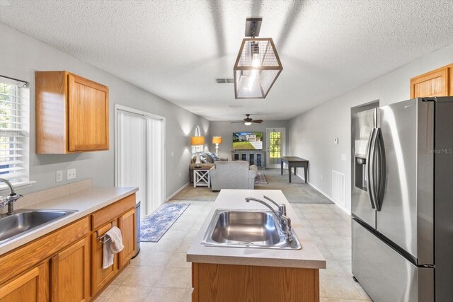 2541 W Castle Rd, Citrus Springs, FL 34434 - kitchen with stainless steel fridge with ice dispenser, a sink, a ceiling fan, light countertops, and a textured ceiling