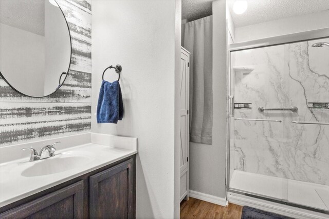 2541 W Castle Rd, Citrus Springs, FL 34434 - bathroom with a textured ceiling, a marble finish shower, vanity, wood finished floors, and baseboards