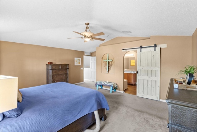 2541 W Castle Rd, Citrus Springs, FL 34434 - carpeted bedroom with lofted ceiling, baseboards, a barn door, connected bathroom, and a ceiling fan