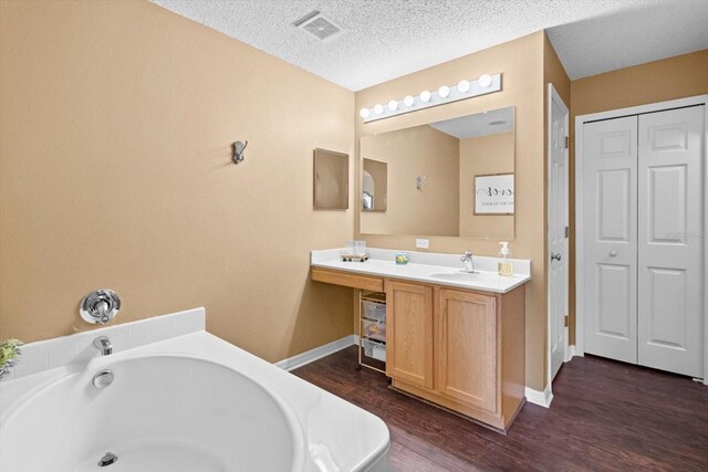 2541 W Castle Rd, Citrus Springs, FL 34434 - bathroom featuring a closet, a bathtub, vanity, wood finished floors, and baseboards