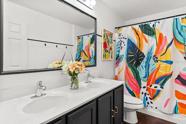 2541 W Castle Rd, Citrus Springs, FL 34434 - full bathroom featuring double vanity, a textured ceiling, wood finished floors, toilet, and a shower with shower curtain