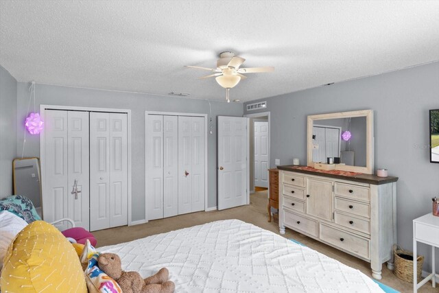 2541 W Castle Rd, Citrus Springs, FL 34434 - bedroom featuring multiple closets, a textured ceiling, and a ceiling fan