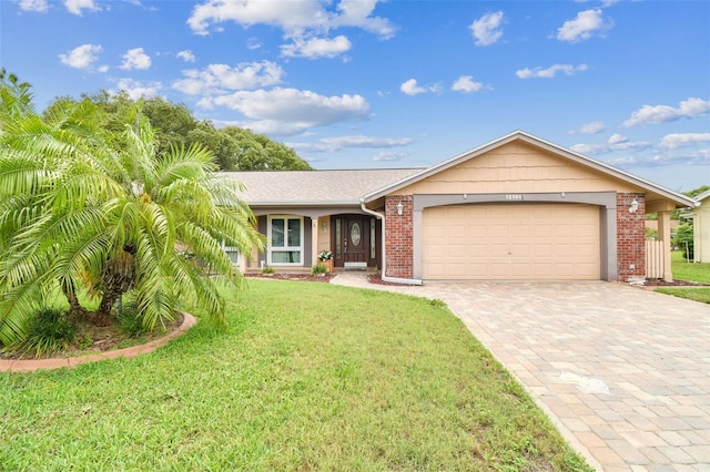 12101 Meadowbrook Ln, Hudson, FL 34667 - single story home featuring decorative driveway, a garage, a front lawn, and brick siding