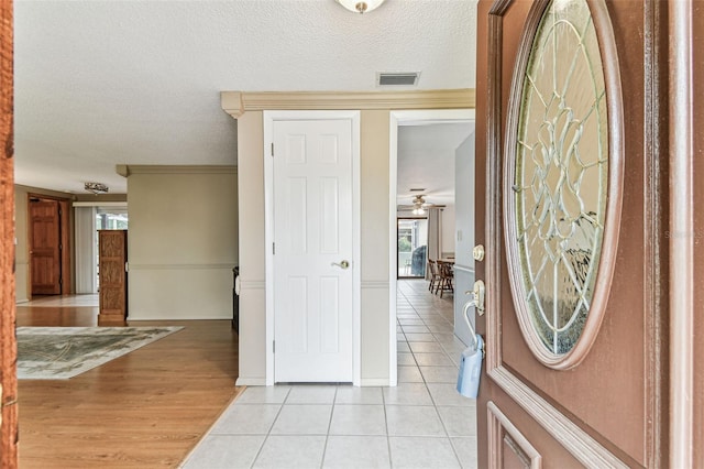 12101 Meadowbrook Ln, Hudson, FL 34667 - foyer entrance featuring light tile patterned floors, a textured ceiling, and a ceiling fan