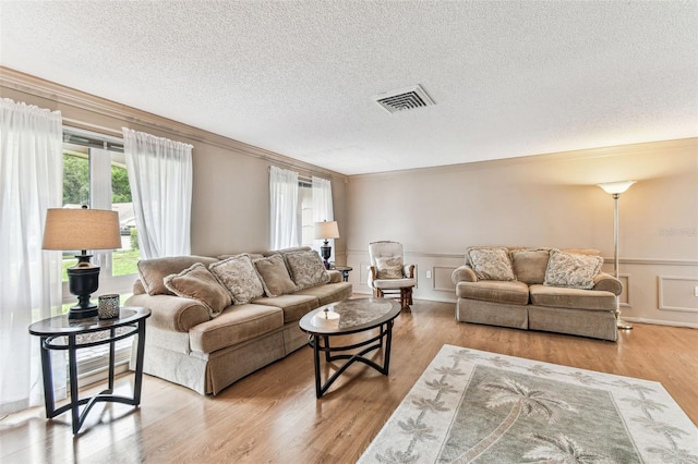 12101 Meadowbrook Ln, Hudson, FL 34667 - living area featuring crown molding, a textured ceiling, wood finished floors, and wainscoting