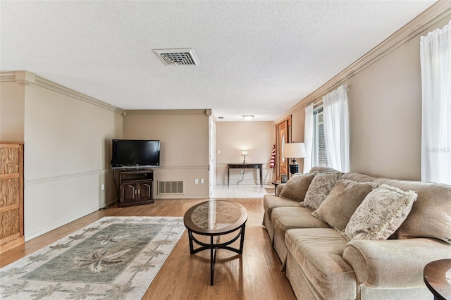 12101 Meadowbrook Ln, Hudson, FL 34667 - living area featuring wood finished floors, a textured ceiling, crown molding, and baseboards