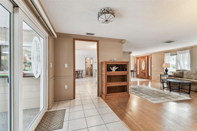 12101 Meadowbrook Ln, Hudson, FL 34667 - entrance foyer with a textured ceiling, ornamental molding, and light tile patterned floors