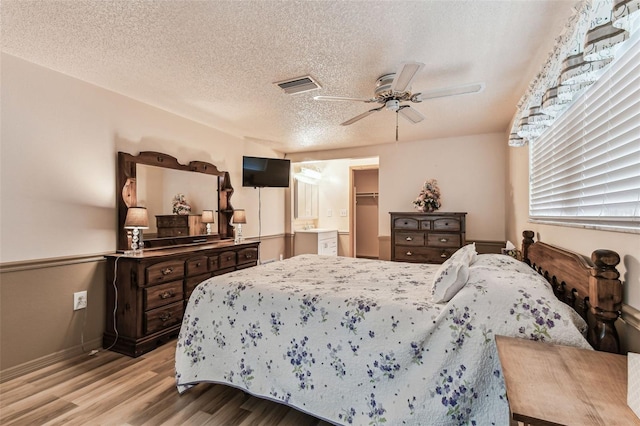 12101 Meadowbrook Ln, Hudson, FL 34667 - bedroom featuring light wood finished floors, baseboards, a textured ceiling, and a ceiling fan
