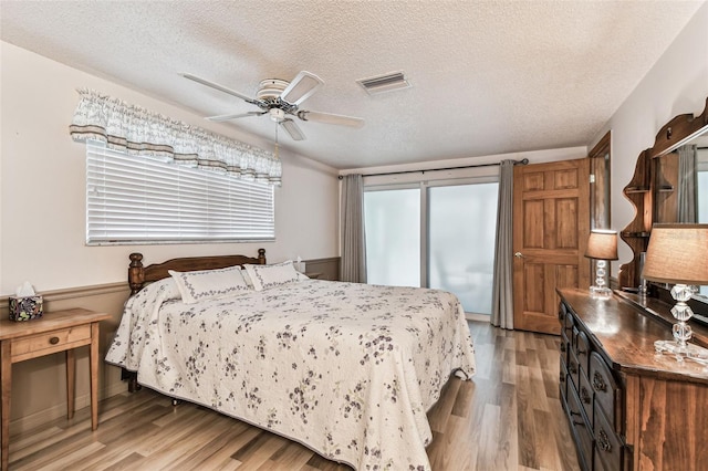 12101 Meadowbrook Ln, Hudson, FL 34667 - bedroom with light wood-style flooring, a textured ceiling, and ceiling fan