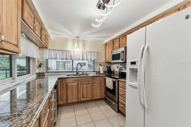 12101 Meadowbrook Ln, Hudson, FL 34667 - kitchen with appliances with stainless steel finishes, a sink, tasteful backsplash, brown cabinets, and light tile patterned floors