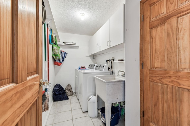 12101 Meadowbrook Ln, Hudson, FL 34667 - laundry room with cabinet space, a textured ceiling, light tile patterned floors, and washing machine and clothes dryer