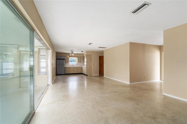13898 Jamaica Dr, Seminole, FL 33776 - unfurnished living room with dark aggregate flooring and a ceiling fan