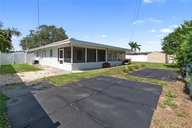 13898 Jamaica Dr, Seminole, FL 33776 - rear view of property with a sunroom, a shed, a gate, and a fenced backyard