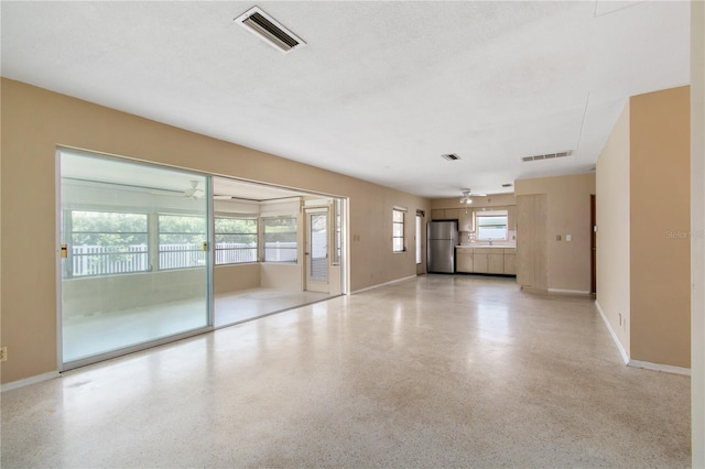 13898 Jamaica Dr, Seminole, FL 33776 - unfurnished living room featuring speckled floor and baseboards