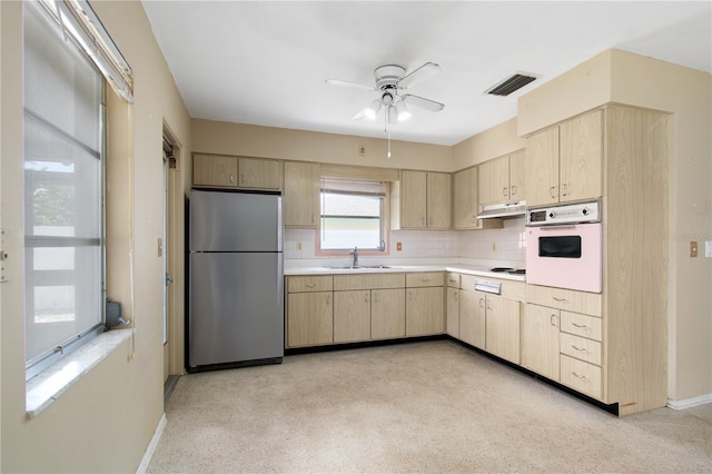 13898 Jamaica Dr, Seminole, FL 33776 - kitchen with freestanding refrigerator, oven, light brown cabinetry, under cabinet range hood, and ceiling fan