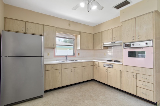 13898 Jamaica Dr, Seminole, FL 33776 - kitchen with white appliances, light brown cabinetry, under cabinet range hood, and decorative backsplash