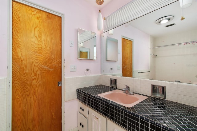 13898 Jamaica Dr, Seminole, FL 33776 - bathroom with vanity and tasteful backsplash