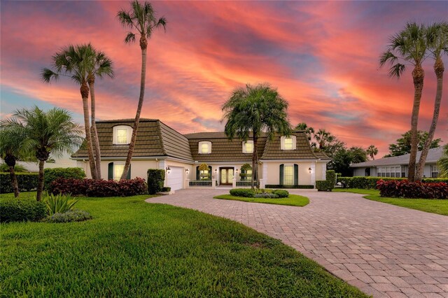 224 Harbor View Ln, Largo, FL 33770 - view of property with decorative driveway, an attached garage, a front lawn, mansard roof, and a tile roof