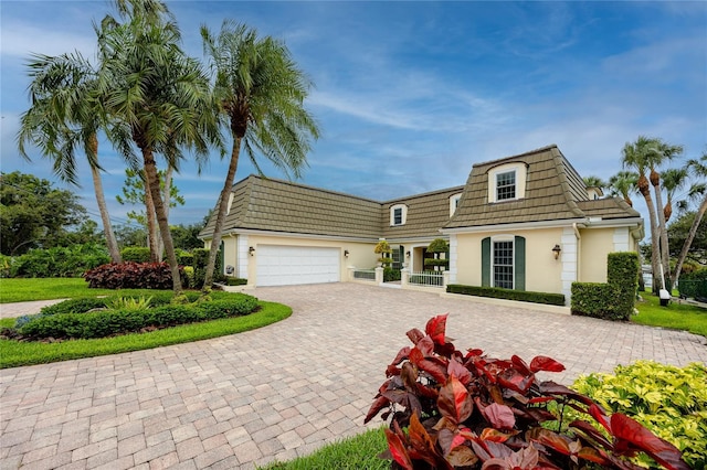 224 Harbor View Ln, Largo, FL 33770 - view of property featuring stucco siding, decorative driveway, a garage, mansard roof, and a tiled roof