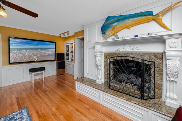 224 Harbor View Ln, Largo, FL 33770 - unfurnished living room with a premium fireplace, light wood finished floors, ceiling fan, ornamental molding, and a wainscoted wall