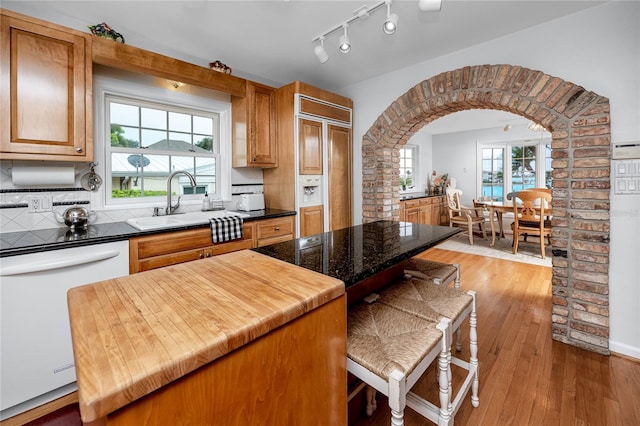 224 Harbor View Ln, Largo, FL 33770 - kitchen featuring dishwasher, light wood-style floors, arched walkways, and paneled built in refrigerator