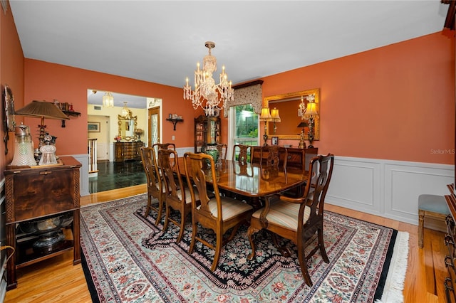 224 Harbor View Ln, Largo, FL 33770 - dining space with a chandelier, wainscoting, and light wood finished floors