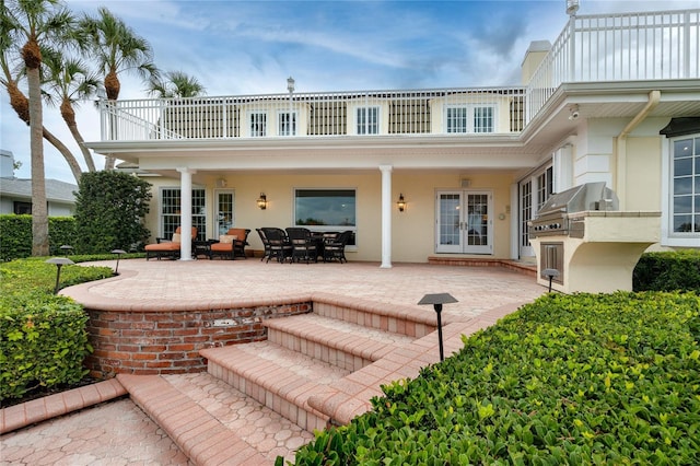 224 Harbor View Ln, Largo, FL 33770 - back of house featuring a balcony, french doors, a patio area, stucco siding, and exterior kitchen