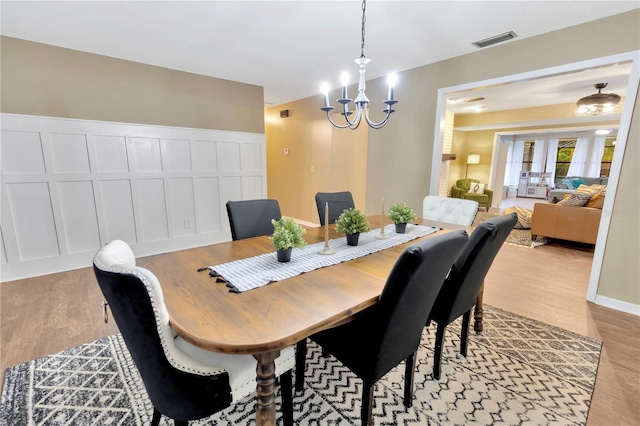 9615 Raiden Ln, Riverview, FL 33569 - dining space with a chandelier, light wood finished floors, and a decorative wall