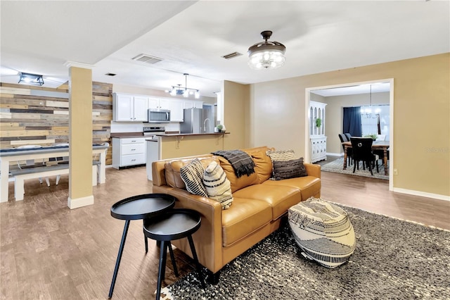 9615 Raiden Ln, Riverview, FL 33569 - living area featuring light wood-style flooring, a chandelier, and baseboards