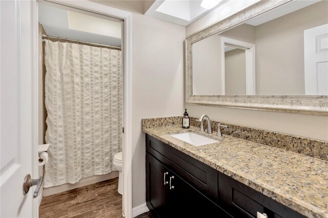 9615 Raiden Ln, Riverview, FL 33569 - full bathroom featuring toilet, vanity, wood finished floors, and a shower with shower curtain