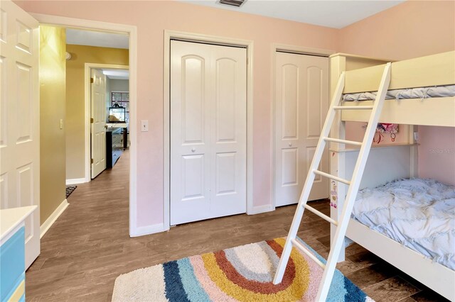 9615 Raiden Ln, Riverview, FL 33569 - bedroom with wood finished floors, baseboards, and two closets
