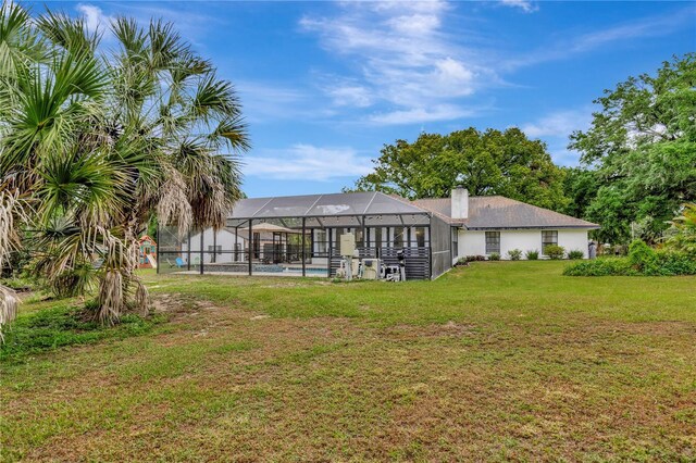 9615 Raiden Ln, Riverview, FL 33569 - back of house featuring a lawn, an outdoor pool, glass enclosure, and a chimney