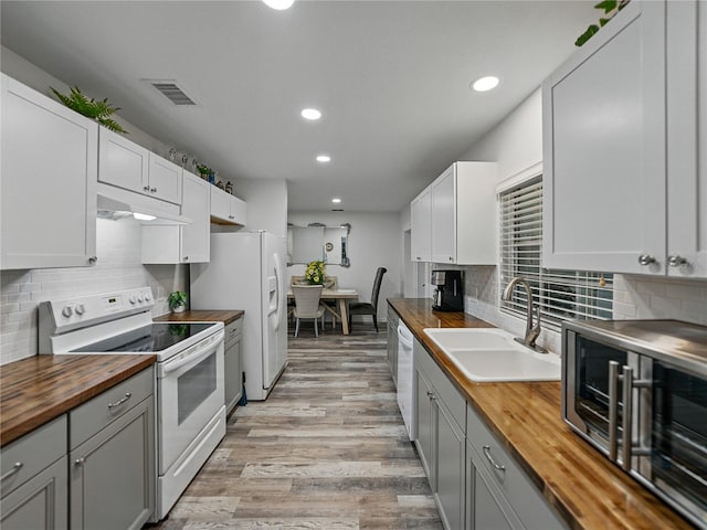 140 Morrow Cir, Brandon, FL 33510 - kitchen featuring butcher block counters, white appliances, a sink, under cabinet range hood, and recessed lighting