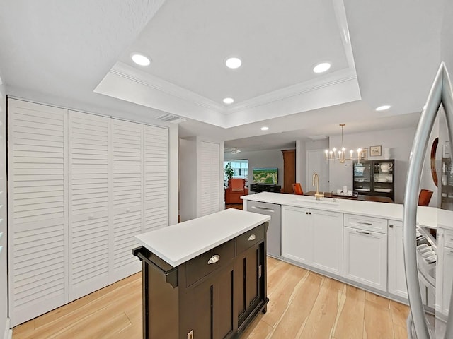 3504 Wedge Way, New Port Richey, FL 34655 - kitchen with a sink, a raised ceiling, stainless steel appliances, a chandelier, and light wood-style floors
