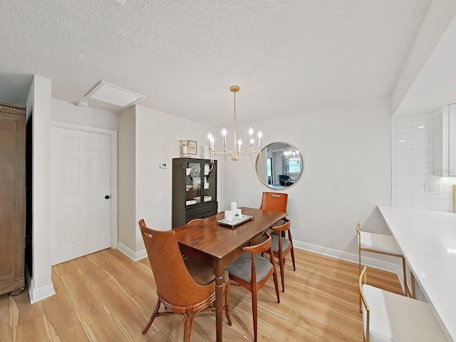 3504 Wedge Way, New Port Richey, FL 34655 - dining area with light wood-type flooring, baseboards, a chandelier, and a textured ceiling