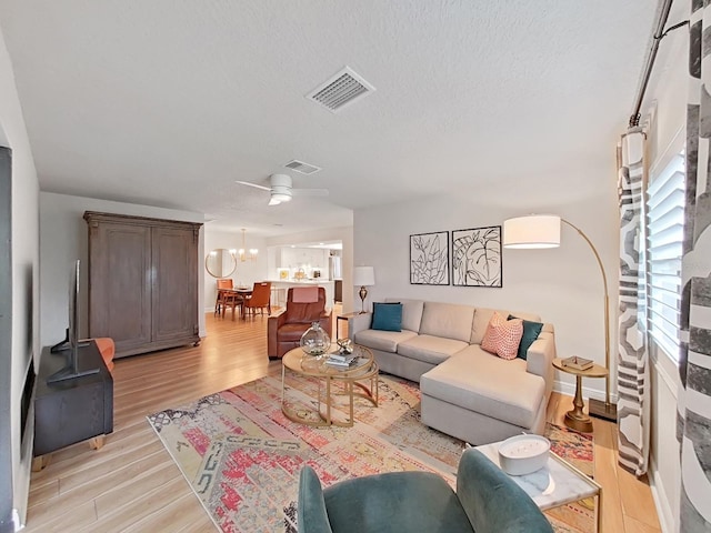 3504 Wedge Way, New Port Richey, FL 34655 - living area with light wood finished floors, a chandelier, and a textured ceiling
