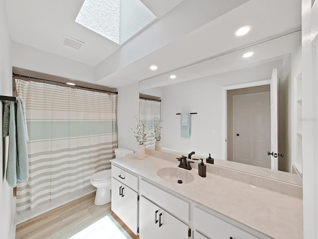 3504 Wedge Way, New Port Richey, FL 34655 - bathroom featuring recessed lighting, vanity, toilet, a skylight, and wood finished floors