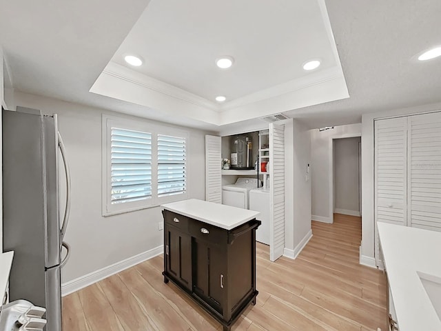 3504 Wedge Way, New Port Richey, FL 34655 - kitchen with freestanding refrigerator, a tray ceiling, light wood finished floors, light countertops, and electric water heater